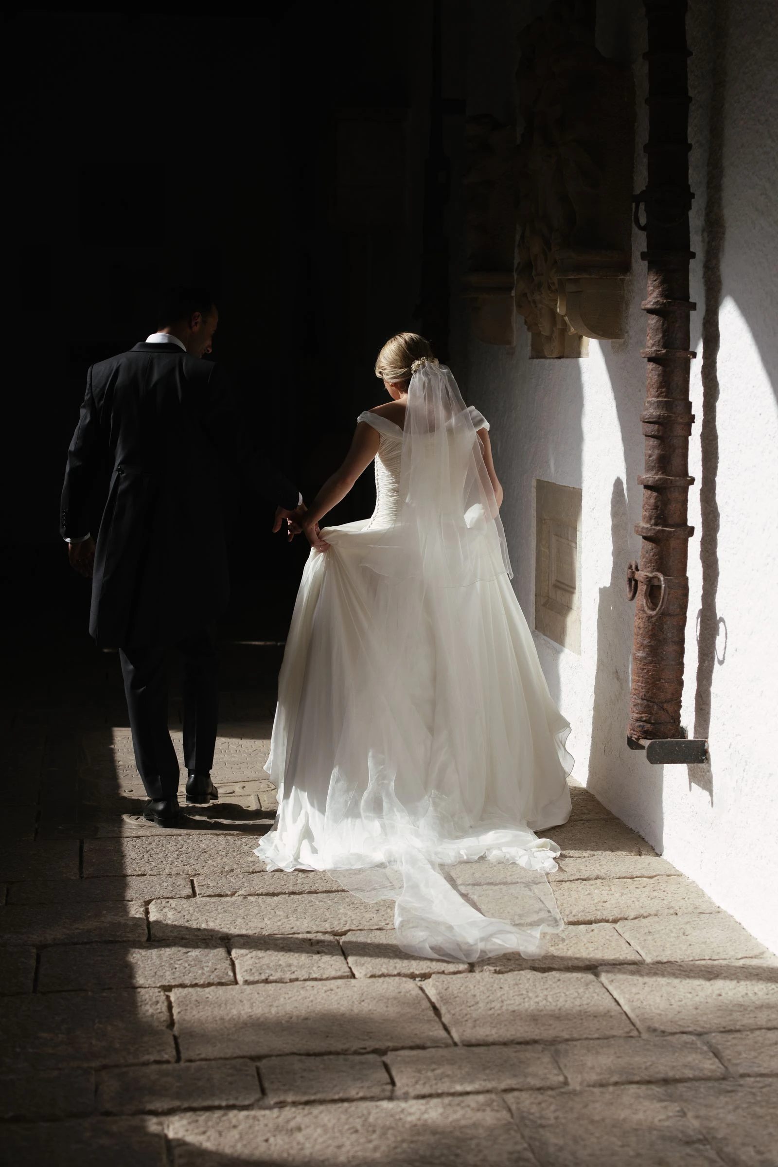 Novios caminando por un patio con luz lateral